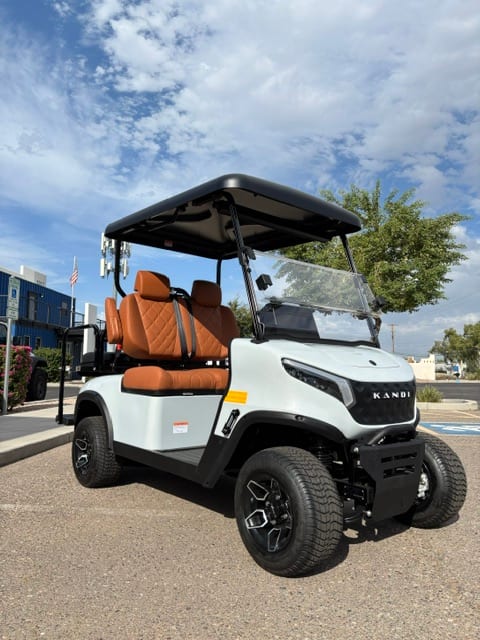 Front three-quarter view of the white KANDI GOAT with cognac diamond-stitched seats