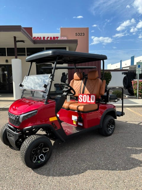Sold sign on the converted red KANDI GOAT in front of the storefront