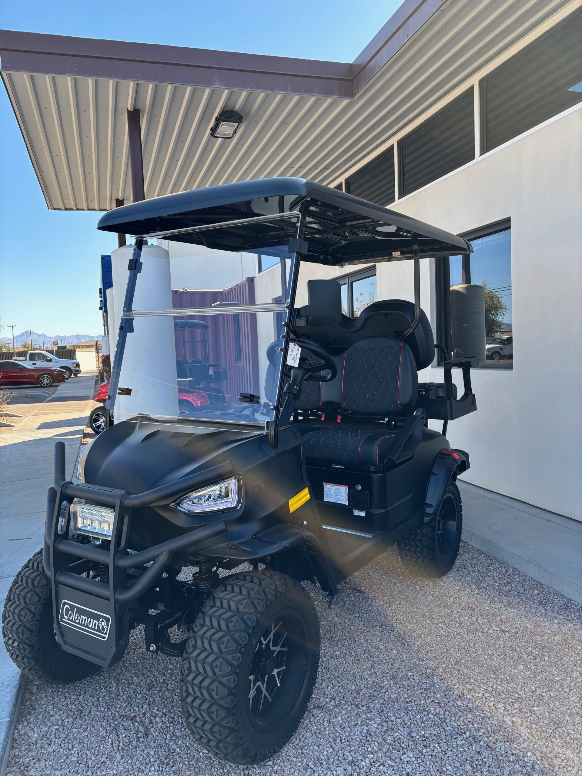 Black lifted golf cart outside the Mesa shop