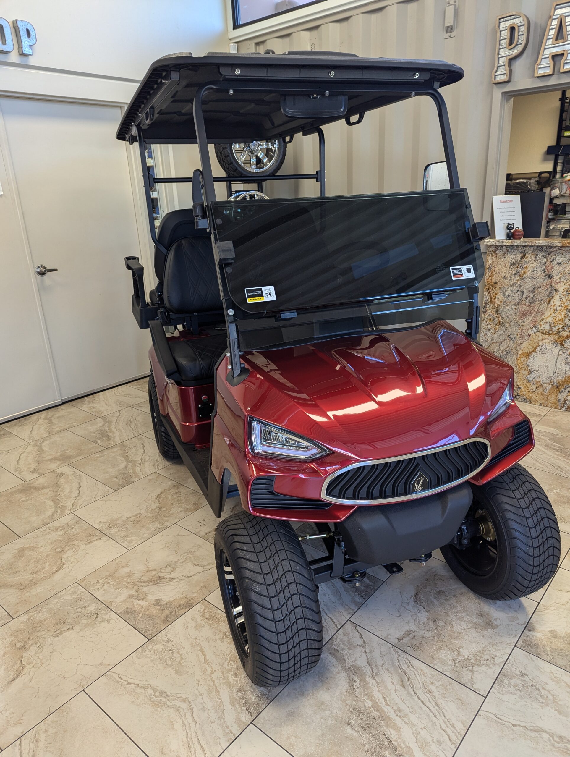 Red KANDI Kruiser golf cart on the Arizona Golf Cart Repair showroom floor